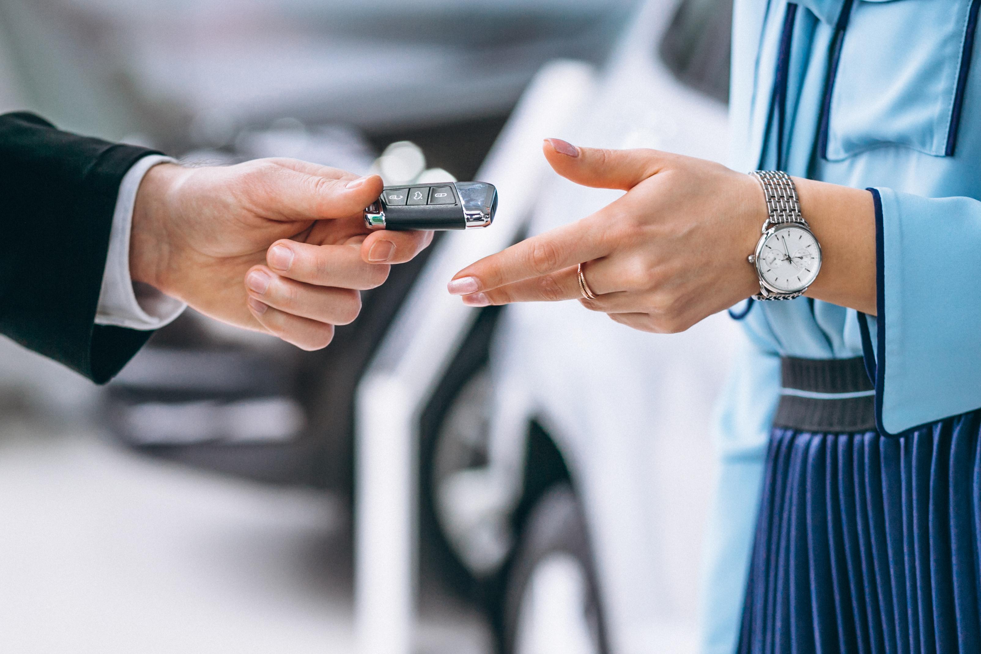 gros plan d'une main de femme qui attrape une clef de voiture
