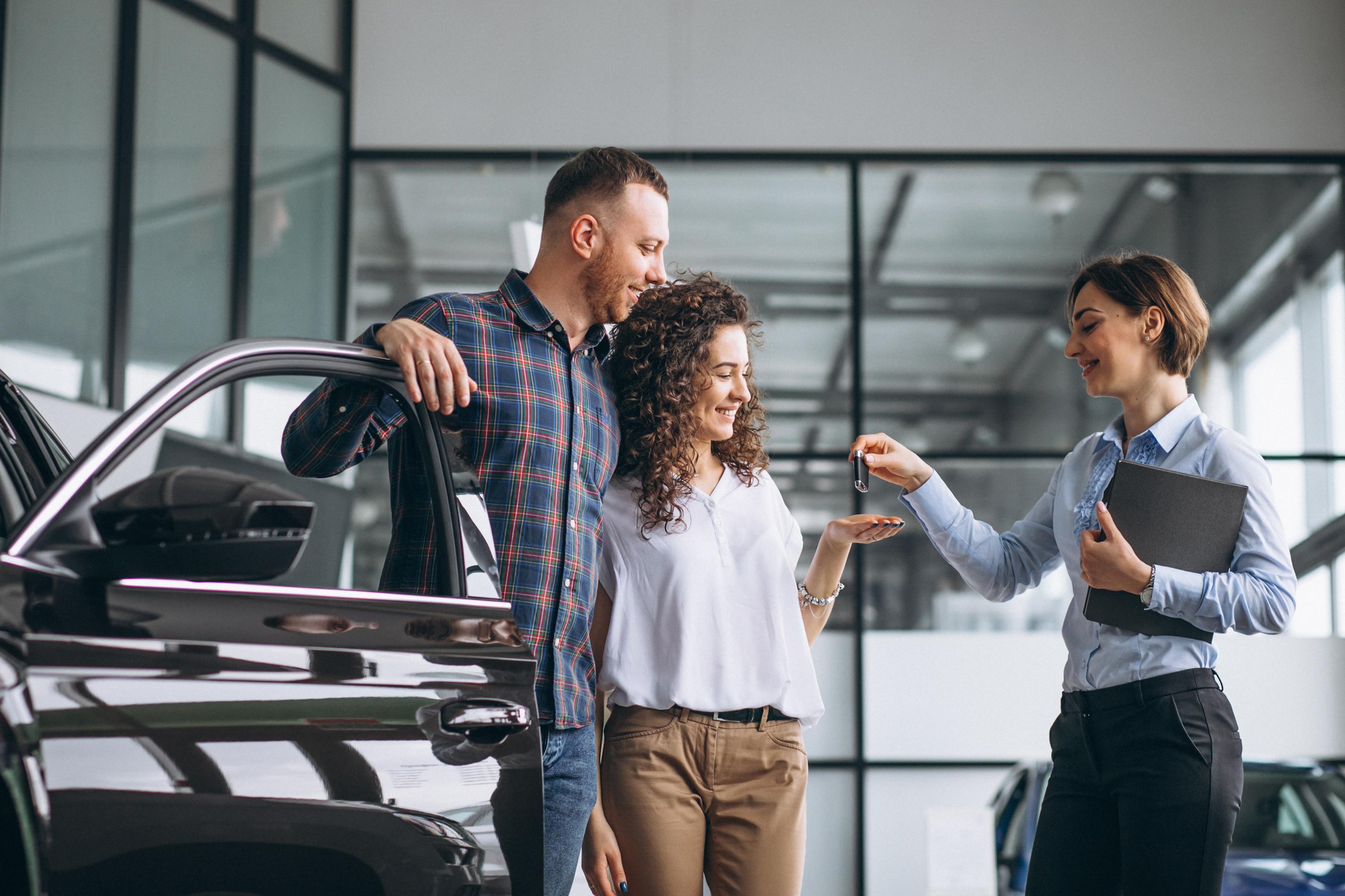jeune couple qui récupèrent les clefs d'une voiture